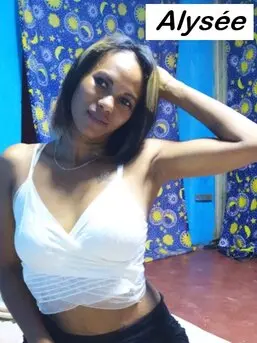 Alysée, hôtesse tél rose visio élégante et souriante, posant en tenue sensuelle. Disponible pour des moments privés, doux et intimes en direct.